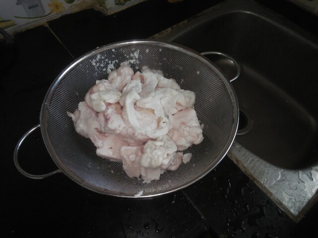 Picture shows pieces of mutton fat in a colander.