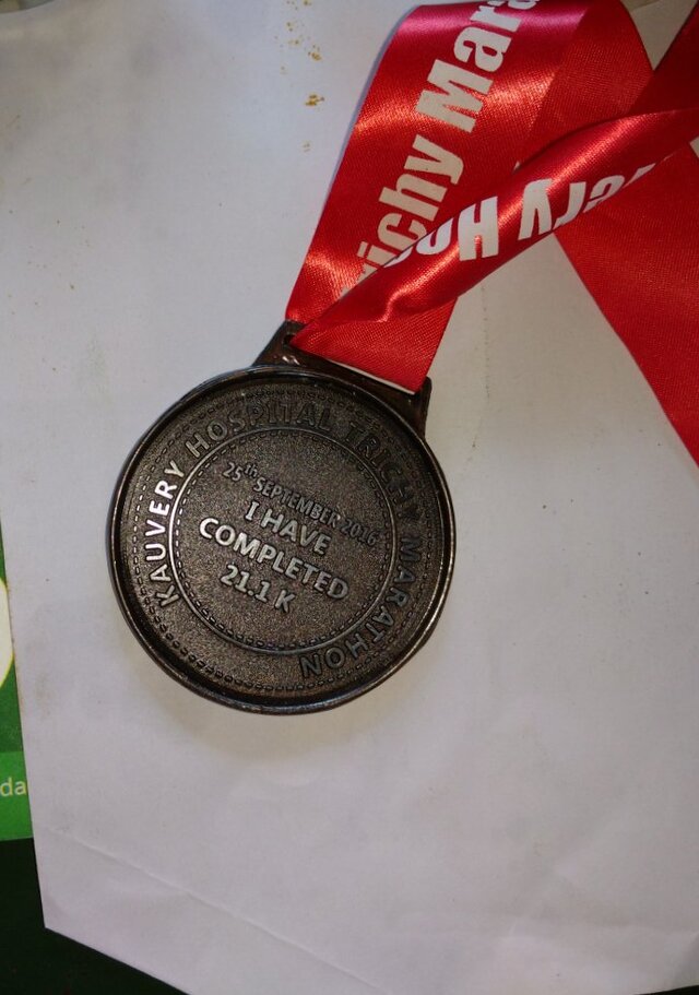 Picture showing the medal (with a red tag) that I received for completing the half marathon