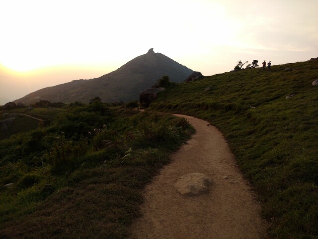 Picture showing sun setting over a flat walking path in Velliangiri hills.